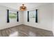 Bedroom with neutral walls, luxury vinyl plank flooring, and two windows providing natural light at 1271 Old Mill Rd, Orlando, FL 32806
