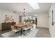 Dining room with a wood table, chandelier, skylight, and an open view into the modern kitchen at 1271 Old Mill Rd, Orlando, FL 32806