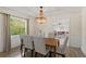 Bright dining room features a modern light fixture, wood floors, and views of the landscaped yard at 1271 Old Mill Rd, Orlando, FL 32806