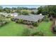 An aerial view of a brick house with a well-manicured lawn, mature trees, and an expansive roof at 1271 Old Mill Rd, Orlando, FL 32806
