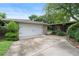 Spacious two-car garage with a clean concrete driveway and verdant landscaping around the exterior at 1271 Old Mill Rd, Orlando, FL 32806