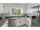 Kitchen boasts granite counters, subway tile backsplash, stainless steel appliances, and white cabinetry at 1271 Old Mill Rd, Orlando, FL 32806