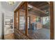 Enclosed patio with brick floor and wood paneled walls with view to kitchen at 1271 Old Mill Rd, Orlando, FL 32806