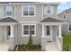 Charming two-story townhome featuring stone accents, a covered entrance, and manicured landscaping at 1315 Tarflower Dr, Winter Springs, FL 32708