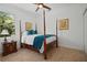Bedroom with a four poster bed frame, wood floors, and natural light at 13631 Via Roma Cir, Clermont, FL 34711