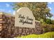 Stone sign for Lake Louisa Highlands community with lush foliage and greenery around at 13631 Via Roma Cir, Clermont, FL 34711