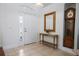 Bright foyer with tile flooring, complemented by a stylish console table and decorative mirror at 13631 Via Roma Cir, Clermont, FL 34711