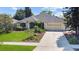 Inviting single-story home featuring a well-kept lawn, driveway, and attractive landscaping at 13631 Via Roma Cir, Clermont, FL 34711