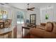 Open-concept living area with wood floors, ceiling fan, and view of screened pool at 13631 Via Roma Cir, Clermont, FL 34711