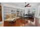Comfortable living room with large custom bookshelves, hardwood flooring, and ample seating at 13631 Via Roma Cir, Clermont, FL 34711