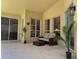 Covered patio with comfortable seating area and view to interior rooms at 13631 Via Roma Cir, Clermont, FL 34711