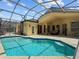 Large screened-in pool with clear blue water and covered patio area at 13631 Via Roma Cir, Clermont, FL 34711