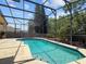 Inviting screened-in pool with clear blue water surrounded by well-kept landscaping and fencing at 13631 Via Roma Cir, Clermont, FL 34711