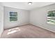 Comfortable bedroom featuring neutral carpet and view to the backyard through two windows at 13794 Sw 112Th St, Dunnellon, FL 34432
