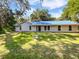 Charming single-story home with a blue metal roof and a well-maintained lawn at 13794 Sw 112Th St, Dunnellon, FL 34432