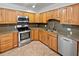 Well-lit kitchen with stainless steel appliances and ample wood cabinet storage at 13794 Sw 112Th St, Dunnellon, FL 34432