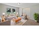 Bright living room features large windows, neutral tones, and comfortable seating arrangement with accent pillows at 13794 Sw 112Th St, Dunnellon, FL 34432
