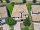 An aerial view of a well-maintained home with a clay tile roof, beautiful landscaping, and a brick driveway at 1478 Moon Valley Dr, Davenport, FL 33896