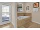 Elegant bathroom showcasing a luxurious soaking tub and access to the outdoors at 1478 Moon Valley Dr, Davenport, FL 33896