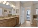 Bathroom with double sink vanity, granite counters, and access to the pool area at 1478 Moon Valley Dr, Davenport, FL 33896