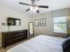 Bright bedroom with a king bed, dark furniture, a large window and a ceiling fan at 1478 Moon Valley Dr, Davenport, FL 33896