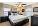 Bright bedroom with a king size bed, ceiling fan, dark furniture, and two windows at 1478 Moon Valley Dr, Davenport, FL 33896