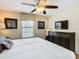 Bedroom with a king bed, ceiling fan, dresser, and a large window with blinds at 1478 Moon Valley Dr, Davenport, FL 33896