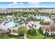 Aerial view of a large community pool with splash pad, winding pools, and palm trees at 1478 Moon Valley Dr, Davenport, FL 33896