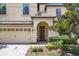 Close up front exterior featuring an arched front porch and two-car garage at 1478 Moon Valley Dr, Davenport, FL 33896