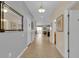 Bright hallway with tile flooring, modern lighting, and neutral wall colors leading to an open-concept living space at 1478 Moon Valley Dr, Davenport, FL 33896