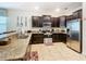 Spacious kitchen with stainless steel appliances, granite countertops, and dark wood cabinets, complete with tile flooring at 1478 Moon Valley Dr, Davenport, FL 33896