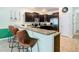 Well-lit kitchen with stainless steel appliances and granite countertops featuring a breakfast bar and barstool seating at 1478 Moon Valley Dr, Davenport, FL 33896