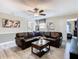 The living room includes a leather sofa, ceiling fan, and grey laminate flooring at 1478 Moon Valley Dr, Davenport, FL 33896