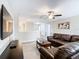 Living room features a leather sofa, ceiling fan, and grey laminate flooring at 1478 Moon Valley Dr, Davenport, FL 33896