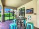 Covered patio area with outdoor seating, bar table, and view of the screened pool at 1478 Moon Valley Dr, Davenport, FL 33896