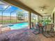Relaxing outdoor living space with a screened-in pool, spa, covered patio, and dining area at 1478 Moon Valley Dr, Davenport, FL 33896