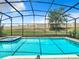 An inviting screened-in pool and spa, complete with a decorative privacy wall at 1478 Moon Valley Dr, Davenport, FL 33896