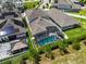 Aerial view featuring a pool, screened-in lanai, and lush landscaping in a residential backyard at 14955 Lebeau Loop, Winter Garden, FL 34787