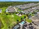 Overhead shot of a community with lush green spaces, a playground, solar panels and sparkling pools in a well-designed layout at 14955 Lebeau Loop, Winter Garden, FL 34787