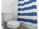 Clean bathroom features a toilet and a shower with a blue striped curtain at 14955 Lebeau Loop, Winter Garden, FL 34787