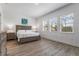 Sunlit bedroom with hardwood floors, a queen bed and a large window at 14955 Lebeau Loop, Winter Garden, FL 34787