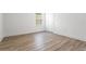Bright empty room features wood floors and a window providing natural light at 14955 Lebeau Loop, Winter Garden, FL 34787