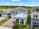 Aerial view of a beautifully landscaped two-story home highlighting the roof, lawn and brick paver driveway at 14955 Lebeau Loop, Winter Garden, FL 34787