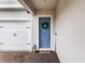 Inviting front entrance showcasing a blue door with wreath, lantern, and 'Welcome' sign, complemented by a brick paver walkway at 14955 Lebeau Loop, Winter Garden, FL 34787
