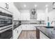 Modern kitchen boasts white cabinets, granite countertops, and stainless steel appliances at 14955 Lebeau Loop, Winter Garden, FL 34787