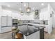 Modern kitchen with large center island, white cabinets, and granite countertops at 14955 Lebeau Loop, Winter Garden, FL 34787