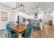 Open kitchen and dining area with modern light fixture and black countertops at 14955 Lebeau Loop, Winter Garden, FL 34787