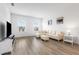 Bright living room boasts modern decor, wood floors, and natural light from the large windows at 14955 Lebeau Loop, Winter Garden, FL 34787