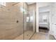 Sleek bathroom shower with glass enclosure, neutral tile, and view to a bedroom at 14955 Lebeau Loop, Winter Garden, FL 34787
