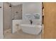 Modern bathroom featuring a freestanding tub, glass-enclosed shower, and wood-look built-ins at 15198 E Oakland Ave, Winter Garden, FL 34787